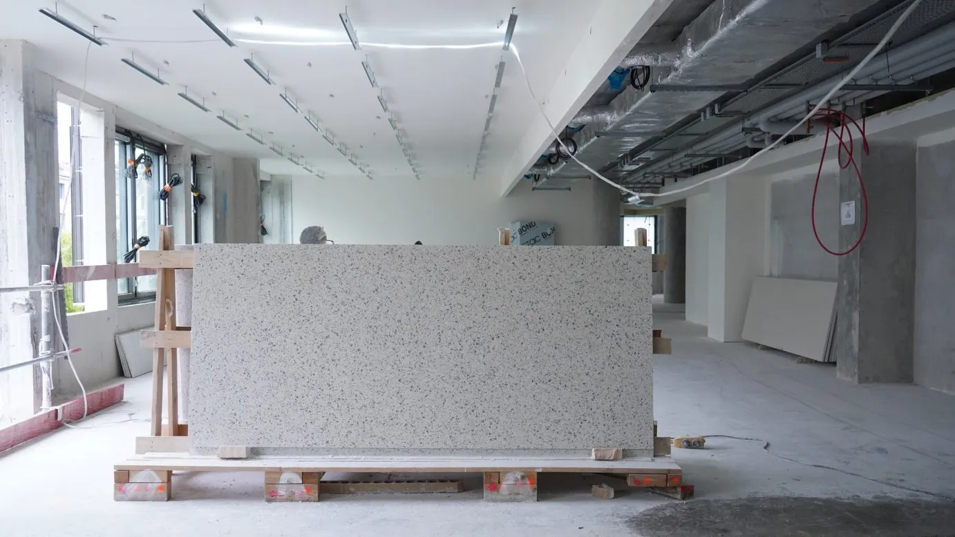 Le granit initialement en parement de façade a été recyclé en un nouveau matériau : le terrazzo en revêtement de sol et faïences dans les sanitaires