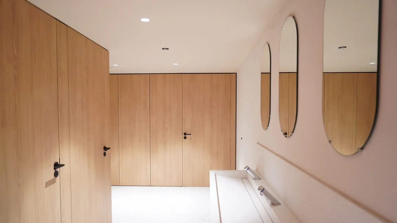 Le granit initialement en parement de façade a été recyclé en un nouveau matériau : le terrazzo en revêtement de sol et faïences dans les sanitaires